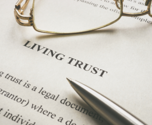 paper that reads "living trust" with pen and glasses on it