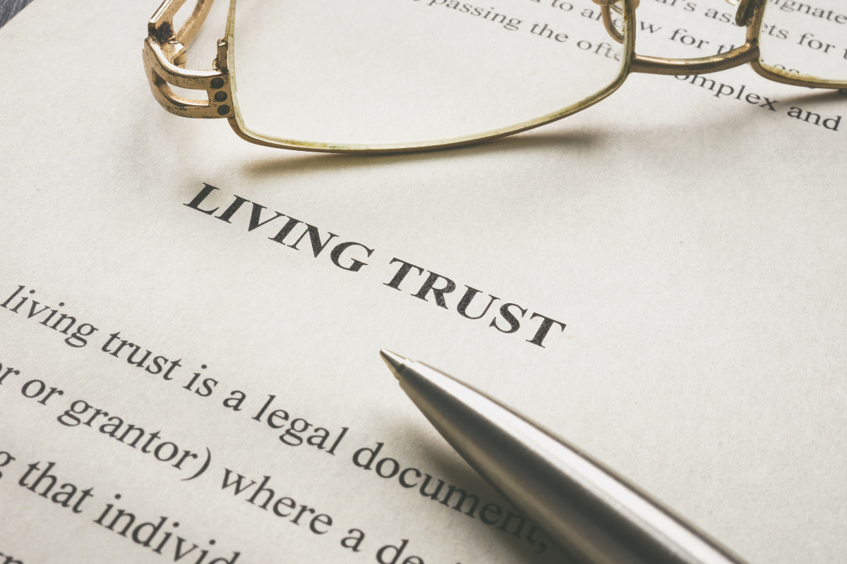 paper that reads "living trust" with pen and glasses on it