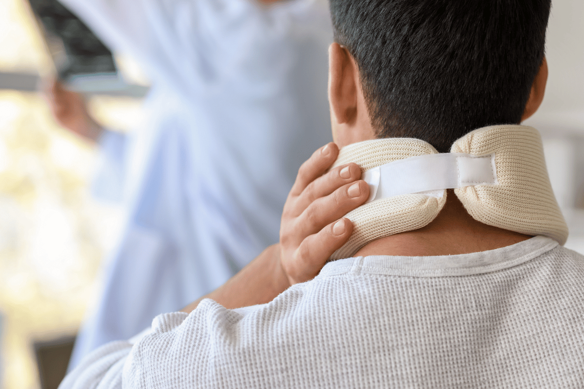 man clutching at his neck brace