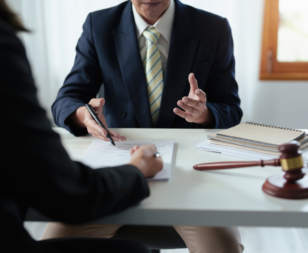 attorney sitting across from client discussing paperwork with a gavel